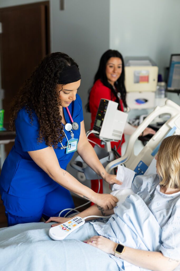 nurse operating medical equipment while assisting patient in healthcare setting