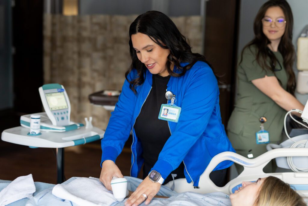 nurse using medical device while assisting patient during healthcare brand photography session