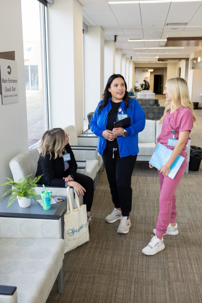 healthcare team talking together in clinic hallway during workday
