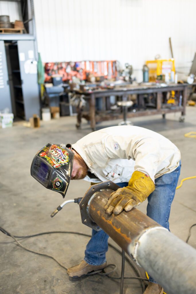 welder working on pipe in industrial setting