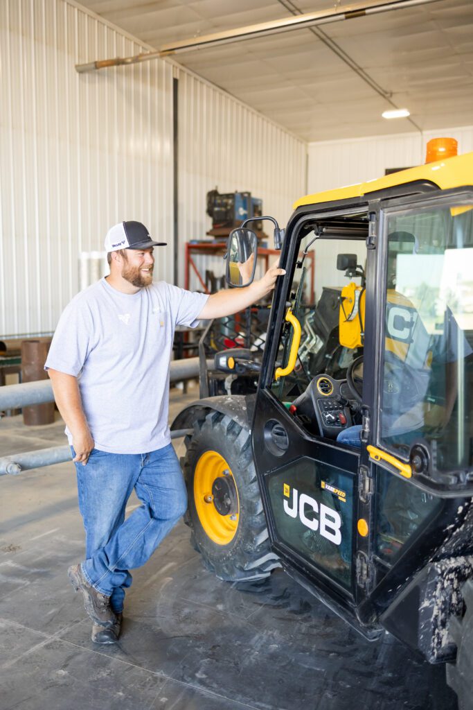 worker standing beside industrial equipment vehicle