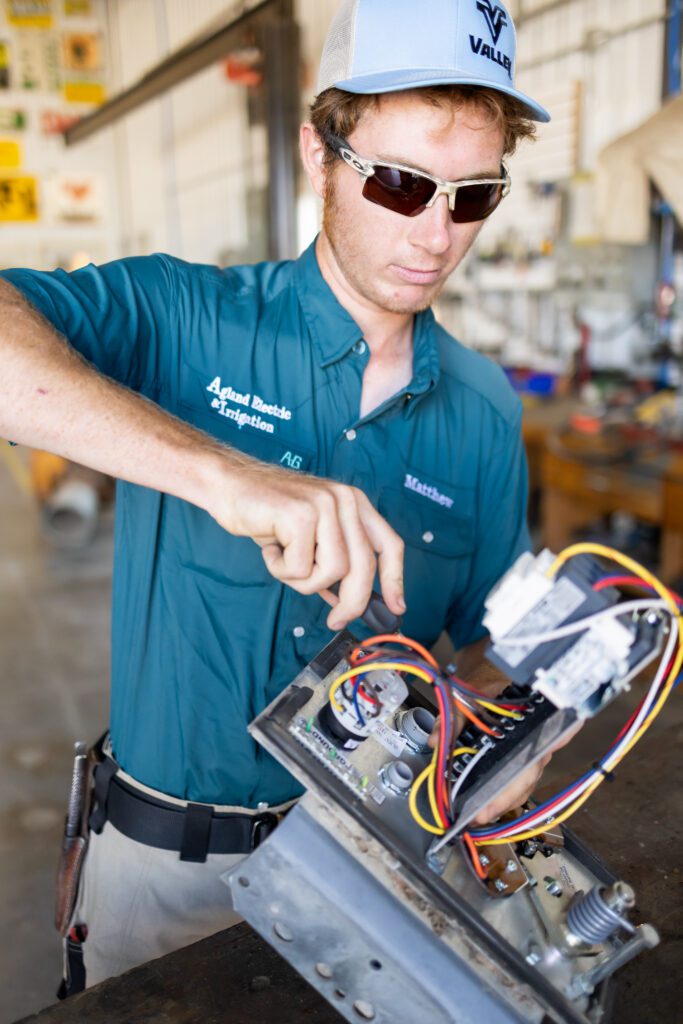 technician repairing wiring inside equipment