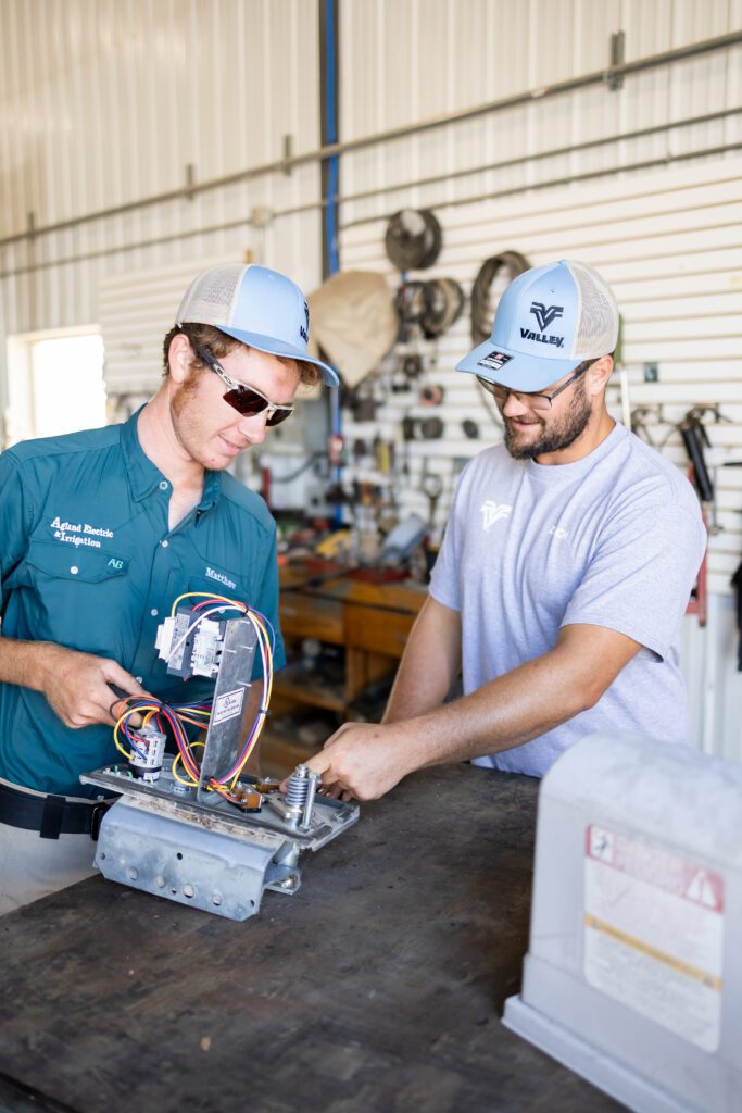 technicians inspecting electrical wiring in workshop
